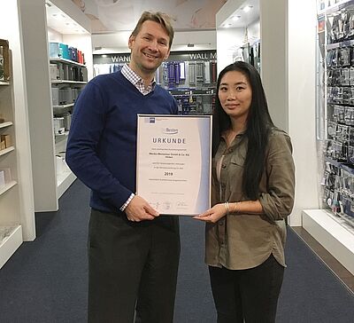 Geschäftsführer Philip Köllner mit der Auszubildenden Li-Li Lam und ihrer Auszeichnung