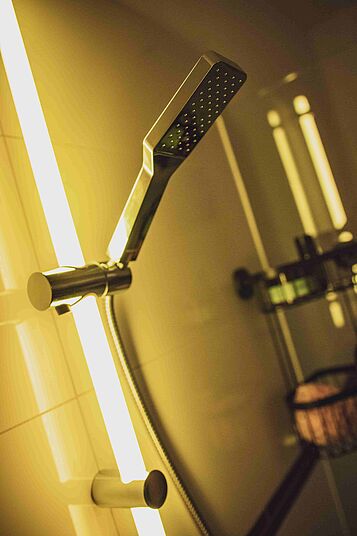 WENKO BAD LED Duschstange gelb Ein weißed Bad mit dem Fokus auf die LED Duschstange in gelb